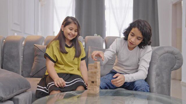 Happy Indian kids playing Jenga at home