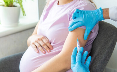 Fototapeta na wymiar A pregnant woman makes a vaccination. Selective focus.