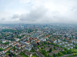 Fototapeta na wymiar Aerial view of City of Zürich north on a cloudy spring morning seen from public park named Irchel with cloudy sky background. Photo taken May 9th, 2023, Zurich, Switzerland.