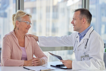 Doctor comforting and supporting sad senior woman patient having bad diagnosis, disease or health problem. Empathy consoling concept at medical consultation