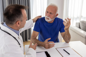 Doctor comforting and supporting distressed, upset senior patient having bad diagnosis, disease or...