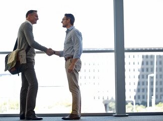 Mature business people, handshake or partnership deal in airport lounge, hotel lobby or modern office for financial crm. Smile, happy or corporate men shaking hands in welcome, thank you or greeting © GR/peopleimages.com