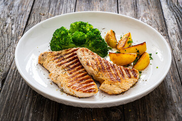 Barbecued turkey breast and broccoli on wooden table 