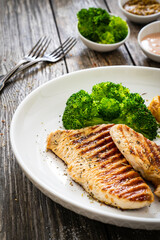 Barbecued turkey breast and broccoli on wooden table 