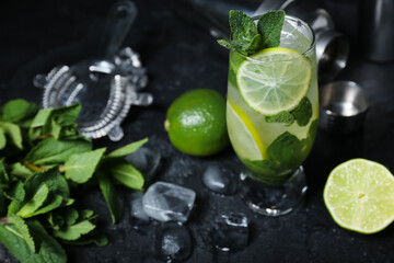 Glass of cold mojito on dark background