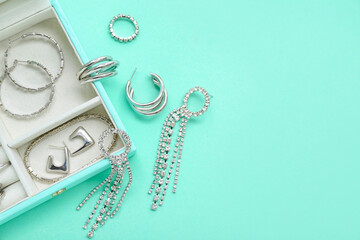 Organizer with stylish jewelry on turquoise background