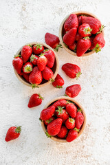 Bowls with fresh strawberries on white background