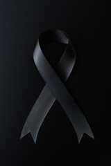 Black mourning ribbon with a dark background. Created with Generative AI Technology