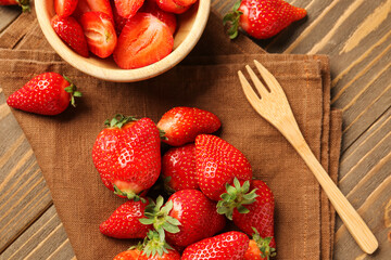 Bowl with fresh strawberries on wooden background