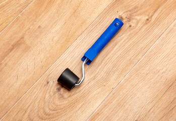 Paint roller on the wooden floor. Top view with copy space