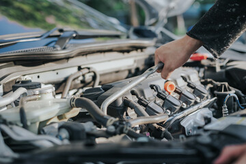 Auto mechanic working, checking engine on site. Repair service.