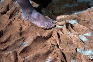 Close up hands of the traditional pottery making in the old way clay and Kneading and mashing the mud with hands and feet
