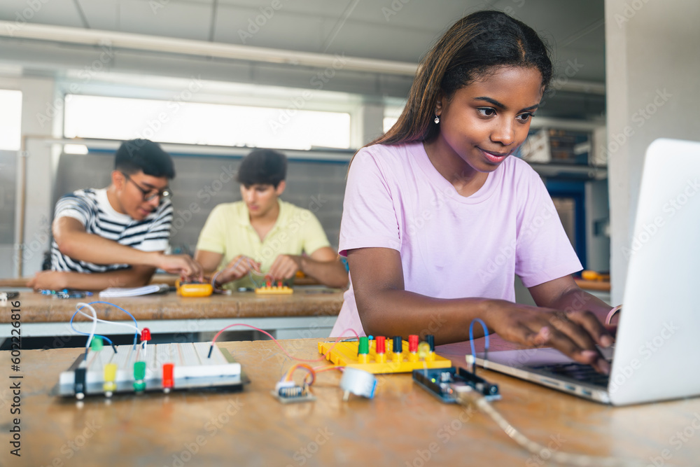 Wall mural female student programming electronics circuit board in the engineering course - technology girl at 