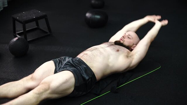 Bodybuilder working on his core muscles with crunches in the gym