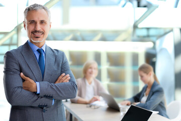 Businessman with colleagues in the background in office.