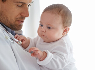 Doctor, pediatrician and baby playing with stethoscope for healthcare assessment, medical support and growth. Newborn kids, man and pediatrics service in clinic, hospital and playful children