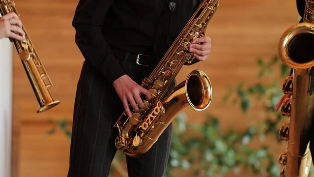 musician in black suit playing the saxophone