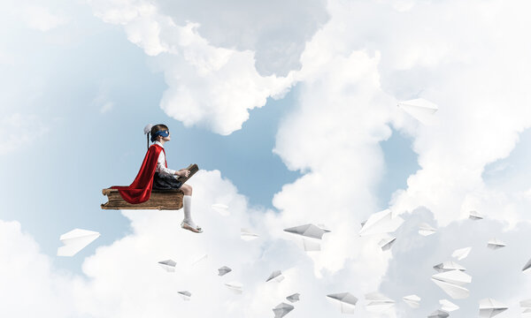 Girl power concept with cute kid guardian against cloudscape background