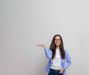 Portrait of smiling sales manager with hand in pocket presenting and advertising against...