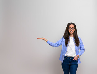 Smiling female professional with hand in pocket showing copy space for advertising against isolated...