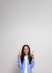 Confident saleswoman smiling and pointing upwards at copy space for promoting and marketing. Female entrepreneur happily gesturing and giving recommendation on background