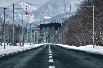 冬の北海道の山間部、センターラインと白い雪が残る道