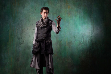 A young man in a Victorian-style suit, a retro character. Antihero or tragic character makes magical passes with his hands,