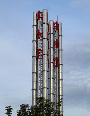 Modern metal pipes for a boiler room. Shiny stainless steel pipes against a cloudy blue sky.