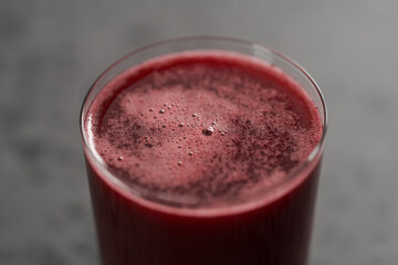 Glass of berry juice on concrete countertop
