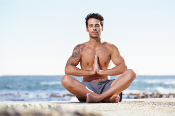 Fototapeta na wymiar Man, relax and yoga in meditation on beach for spiritual wellness, inner peace or mental wellbeing in nature. Calm male yogi in meditate pose for balance, healthy body or mindfulness by the ocean