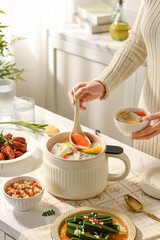 Woman making nutritious soup in kitchen, making soup, rich lunch