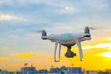 Delivery drone flying over city building sunset sky cloud