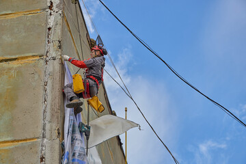 Rope access is a high-risk job. A man works on ropes.