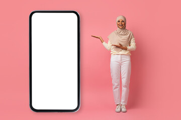 Beautiful Muslim Woman In Hijab Presenting Big Smartphone With White Screen