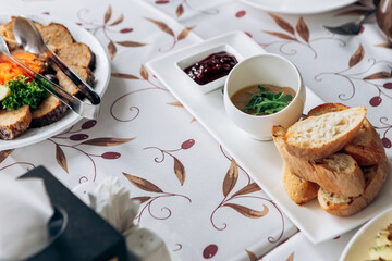 Served table food buffet in restaurant for wedding or birthday party dinner dishes. Assorted meats, chives, bacon, salami, hard cheese with mould and herbs
