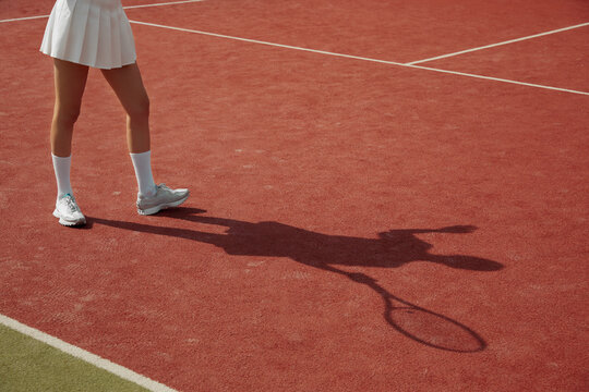 Player shadow on the tennis court carpet during the match. A woman play tennis professionally. Activity for recreation. Tennis player in action. - Powered by Adobe