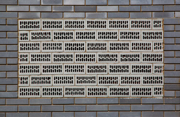 Gray brick wall with a ventilation area made of hollow ceramic blocks