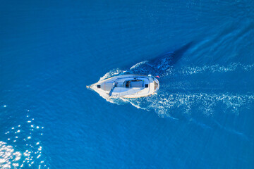 Wave and sail yacht on the sea as a background. .Sea and waves from top view. Blue water background...