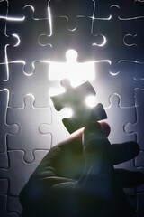 Hand, missing jigsaw puzzle and glow with light for problem solving, ideas and connection. Person, brain power and games with strategy, innovation or synergy for solution, link or creativity for goal