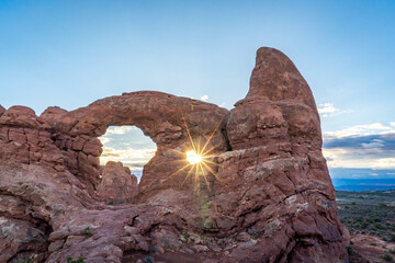 sun rising and shining through turret arch at arches national park in utah usa © DEN