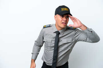 Young caucasian security man isolated on white background looking far away with hand to look something