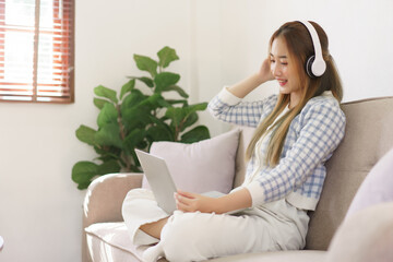 Rest time concept, Women sitting on comfortable couch and wearing headphone to watching movie