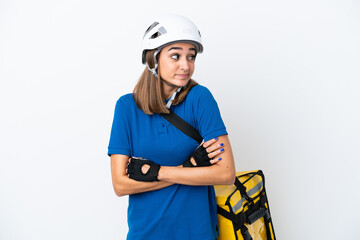 Young caucasian woman with thermal backpack isolated on white background making doubts gesture...