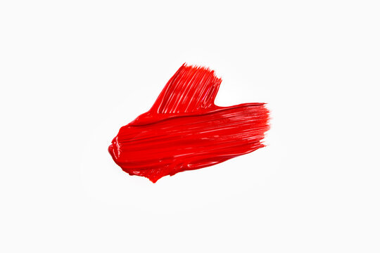 Red strokes of paint, lipstick, cosmetics, on a white background. Top view, flat lay