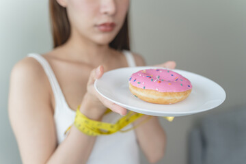 Female tied her hand with measuring tape to avoid eating food have sugar ingredients during diet...