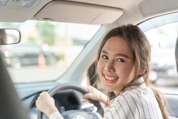 happy Asian woman driving car to journey vacation destination.