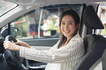 happy Asian woman driving car to journey vacation destination.