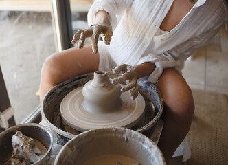 A woman works with clay in a workshop. Making pottery