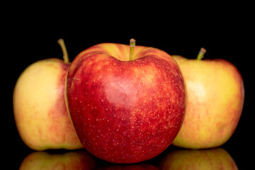 Three ripe red apples, macro, isolated on black background.