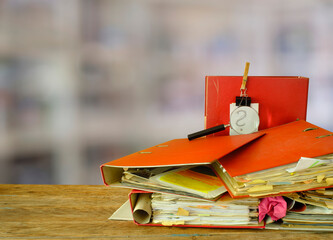messy file folders, magnifying glass with blurred office in the back, red tape, bureaucracy,office, business concept